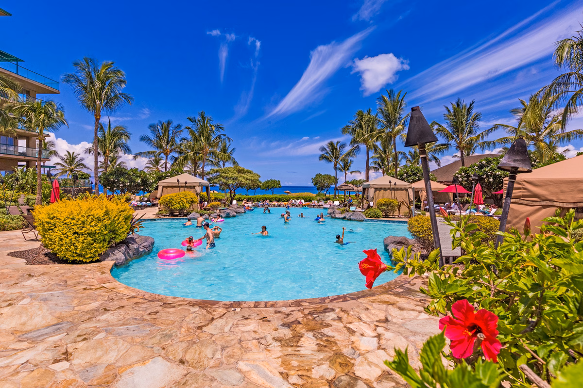 Resort pools with waterfalls and tropical landscaping at Honua Kai